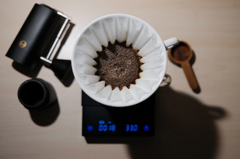 Wie viel Kaffeepulver pro Tasse? Die richtige Dosierung für guten Kaffee 1 Kaffeepulver und Kaffee auf einer Waage zur richtigen Dosierung pro Tasse