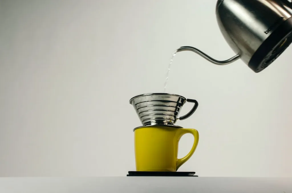Wasser wird auf Kaffeemehl im Handfilter gegossen für das Blooming