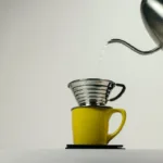 Wasser wird auf Kaffeemehl im Handfilter gegossen für das Blooming
