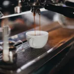 Tasse Kaffee und Kaffeebohnen als Auswahlhilfe für Kaffeevollautomaten