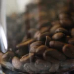 Kaffeebohnen im Mahlwerk als Beispiel für feinen, mittleren und groben Mahlgrad